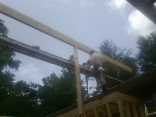 Carpenter setting a ridge beam over a new addition frame — Ice Dam Removal by Roofing Brothers in Monument