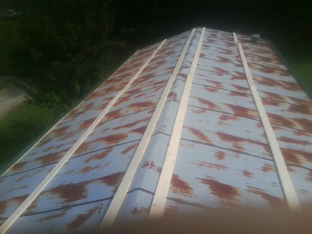 Rusted metal roof panels with new wood purlins before replacement — Storm Damage Roof Repair in Monument by Roofing Brothers