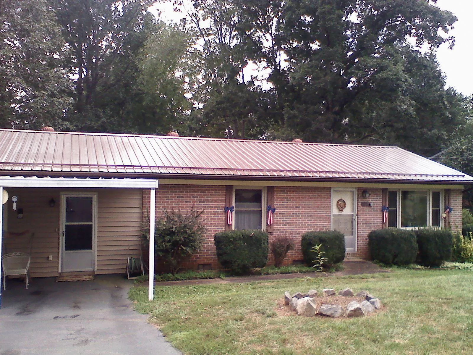 Bronze metal roof and carport on a brick ranch home — Roof Repair work by our crew in Monument