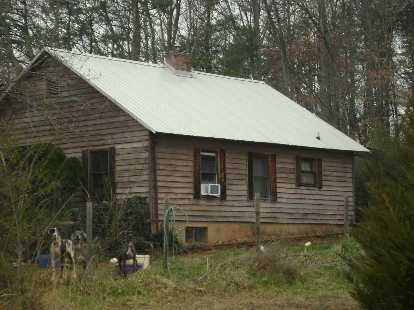 White metal roof on an old wood sided farmhouse, from a Metal Roof Installation job in Monument